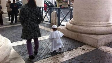 Menino vestido de Papa caminha no Vaticano